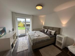 a bedroom with a bed and a large window at Ferienlodge de Ferienwohnung in Schulenberg im Oberharz