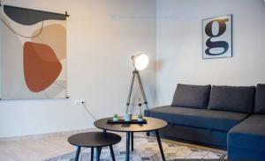 a living room with a blue couch and a table at 65 City Apartment - Comfortable Stay in Volos