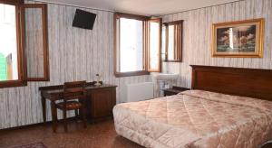 a bedroom with a bed and a table and a desk at Best Holidays Venice in Venice