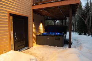 a screened in porch with a tv in the snow at Au Grand Merisier : Chalet alpin in Petite-Rivière-Saint-François