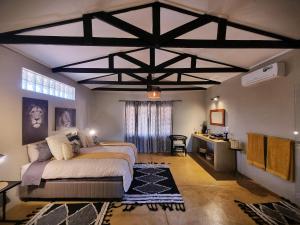 Grietjie Game ReserveNgalali Retreat的卧室里有一张床和一张书桌