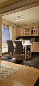 a kitchen with a dining room table and chairs at En liten hytte i Gryllefjord in Gryllefjord
