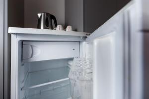 an open refrigerator with a bottle of water in it at Hotel Atom Třebíč in Třebíč