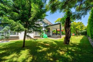 a house with trees in front of a yard at Villa Yakamoz in Fethiye
