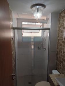 a bathroom with a shower and a chandelier at Apartamento CUESTA -TÉRREO - in Botucatu +17 photos