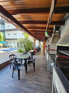a patio with tables and chairs and a grill at Chalés do Bona - Loft 14 in Ubatuba