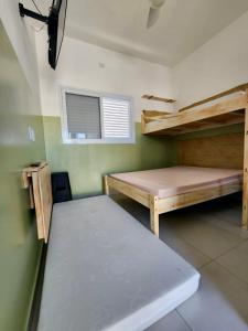 a small room with two bunk beds and a window at Chalés do Bona - Loft 14 in Ubatuba +5 photos