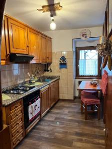 a kitchen with wooden cabinets and a stove top oven at Casa Cardillo in Colere