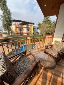 a balcony with a table and chairs and a pool at Govind Villa - 3BHK Penthouse Suite with Pool Splash in Lonavala
