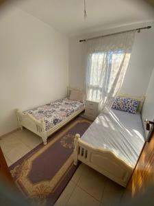 a bedroom with two beds and a window at رياض طنجة مجمع الغابة الدبلوماسية قرية مستشفى الجامعي محمد 6 in Daidatz