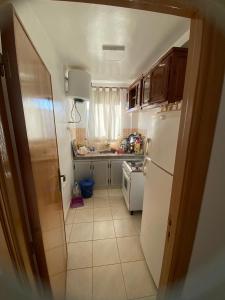 a kitchen with a white refrigerator and a sink at رياض طنجة مجمع الغابة الدبلوماسية قرية مستشفى الجامعي محمد 6 in Daidatz
