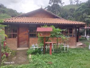 ein kleines Haus mit einem Schild davor in der Unterkunft Morada do sabiá in Resende