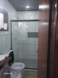 ein Badezimmer mit Toilette und Glasdusche in der Unterkunft Morada do sabiá in Resende