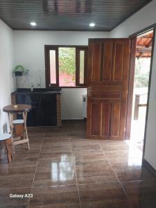 ein Wohnzimmer mit einer Holztür und einem Tisch in der Unterkunft Morada do sabiá in Resende