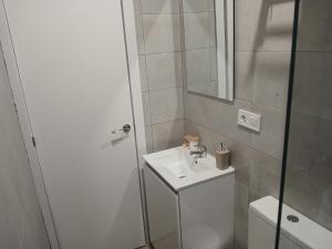 a white bathroom with a sink and a shower at Apartamentos de la mansión in Carmona