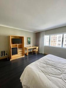 a hotel room with a bed and a desk at Flat particular incrível no hotel Interc Paulista com vaga in Sao Paulo
