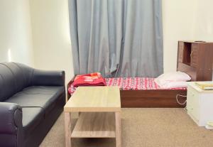 a living room with a couch and a table at Stay home in ‘Uqayr