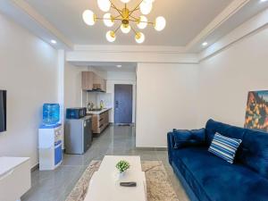a living room with a blue couch and a table at Iconic 1Br in Riverside with views and gym in Nairobi