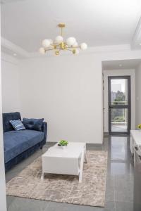 a living room with a blue couch and a table at Iconic 1Br in Riverside with views and gym in Nairobi