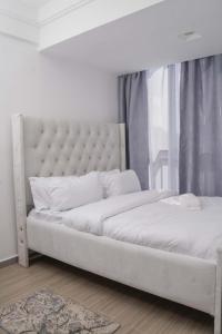 two beds in a bedroom with a white bed frame at Iconic 1Br in Riverside with views and gym in Nairobi