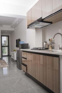 a kitchen with wooden cabinets and a counter top at Iconic 1Br in Riverside with views and gym in Nairobi
