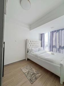 a white bedroom with a large bed and a window at Iconic 1Br in Riverside with views and gym in Nairobi