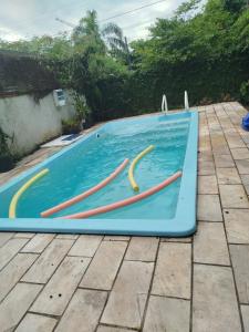 a pool with four wooden paddles in the water at Casa com piscina proximo da praia in Itapoa +4 photos
