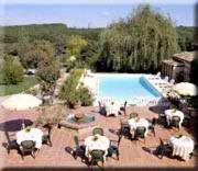 vistas a una piscina con mesas y sillas en Le Ratelier, en Montaigut-sur-Save