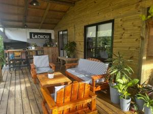 eine Holzterrasse mit Bänken und Tischen und ein Restaurant in der Unterkunft Villa Victoria in Manantiales