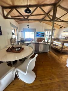 ein Wohnzimmer mit einem Tisch und weißen Stühlen in der Unterkunft Villa Victoria in Manantiales