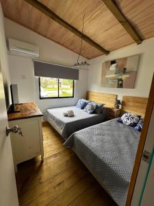 ein Schlafzimmer mit zwei Betten und einem Fernseher darin in der Unterkunft Villa Victoria in Manantiales