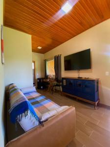 a living room with a couch and a flat screen tv at Delícias da Tilápia em Domingos Martins ES in Domingos Martins
