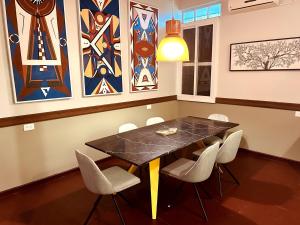 帕拉马里博Villa Rose的一间带桌椅和绘画的用餐室