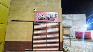 a sign on the side of a building with a garage door at Ojas Royale - Banquet and Hotel in Prayagraj
