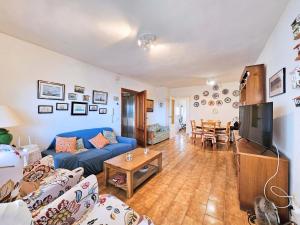 a living room with a blue couch and a table at Las Nuevas Sirenas en La Manga in La Manga del Mar Menor