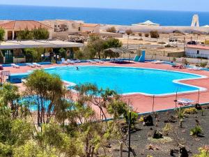 a large pool with chairs and the ocean in the background at Casa Oskar in Costa de Antigua