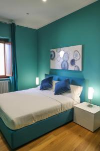a blue bedroom with a large bed with blue walls at 4Suites in Pizzo