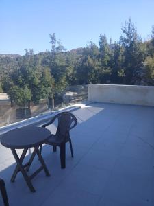 a table and a chair sitting on top of a roof at La MAISON DU VAL in Jbeil