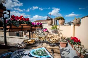 un tavolo con bicchieri da cibo e vino su un balcone di Dimora Torremuzza a Palermo