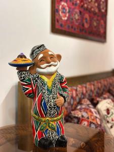 a statue of a man holding a plate of food at Daro Boutique in Bukhara +51 photos