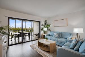 a living room with a blue couch and a table at South Seas Bayside Villa 4116 - Newly Renovated Marina View Condo in Captiva