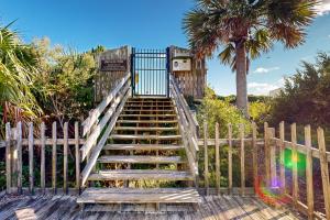 a set of stairs with a gate and a palm tree at Sea Cabin 339-C in Isle of Palms