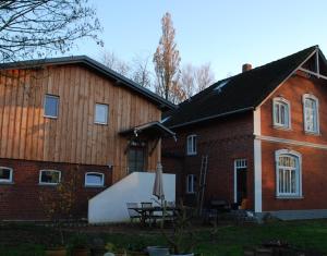 ein Backsteinhaus mit einem Tisch davor in der Unterkunft Himmel&Erden in Nordleda