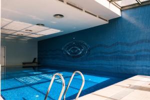 a swimming pool with two chairs in front of a blue wall at MELVİN HOMe in Istanbul