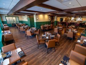 a restaurant with tables and chairs in a room at The Northeastland Hotel in Presque Isle