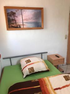 une chambre avec un lit avec un tableau sur le mur dans l'établissement Pension Hanoi, à Hettstedt