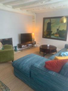 a living room with a blue couch and a table at Blythe Cottage in Long Melford