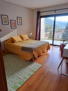 a bedroom with a bed and a large window at Casa Ramada in Vilar da Veiga +19 photos