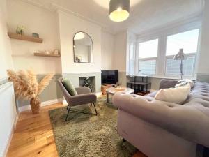 a living room with a couch and chairs and a fireplace at Westcliff-On-Sea Modern 2 Bedroom Apartment - FREE Parking in Southend-on-Sea