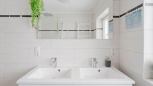 biała łazienka z dwiema umywalkami i lustrem w obiekcie Moderne Ferienwohnung mit Bergblick w mieście Bad Goisern